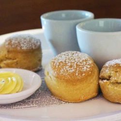 Scones served with cream, butter and mixed berry jam